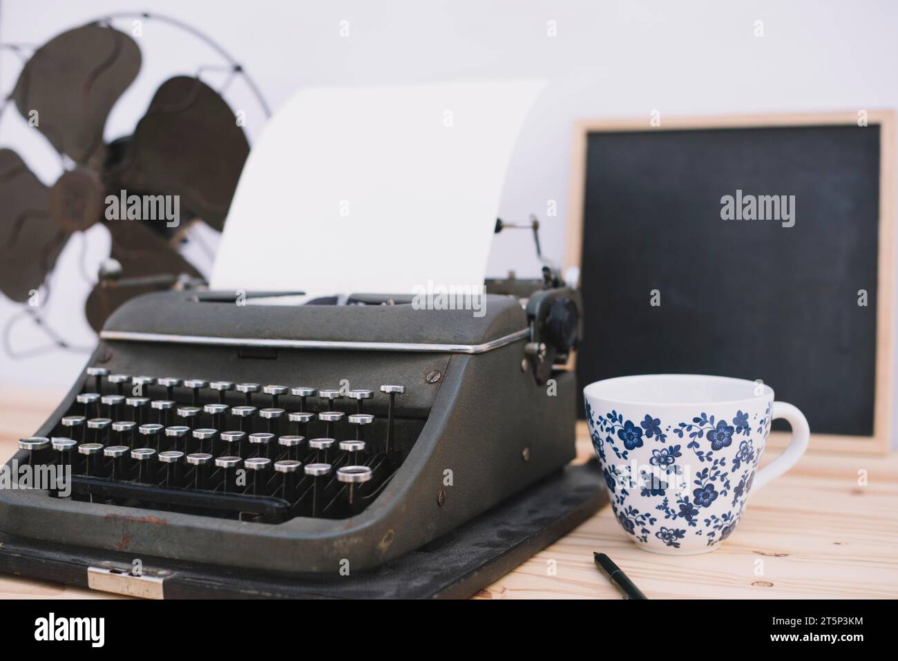 Tasse près de la machine à écrire rétro Banque D'Images