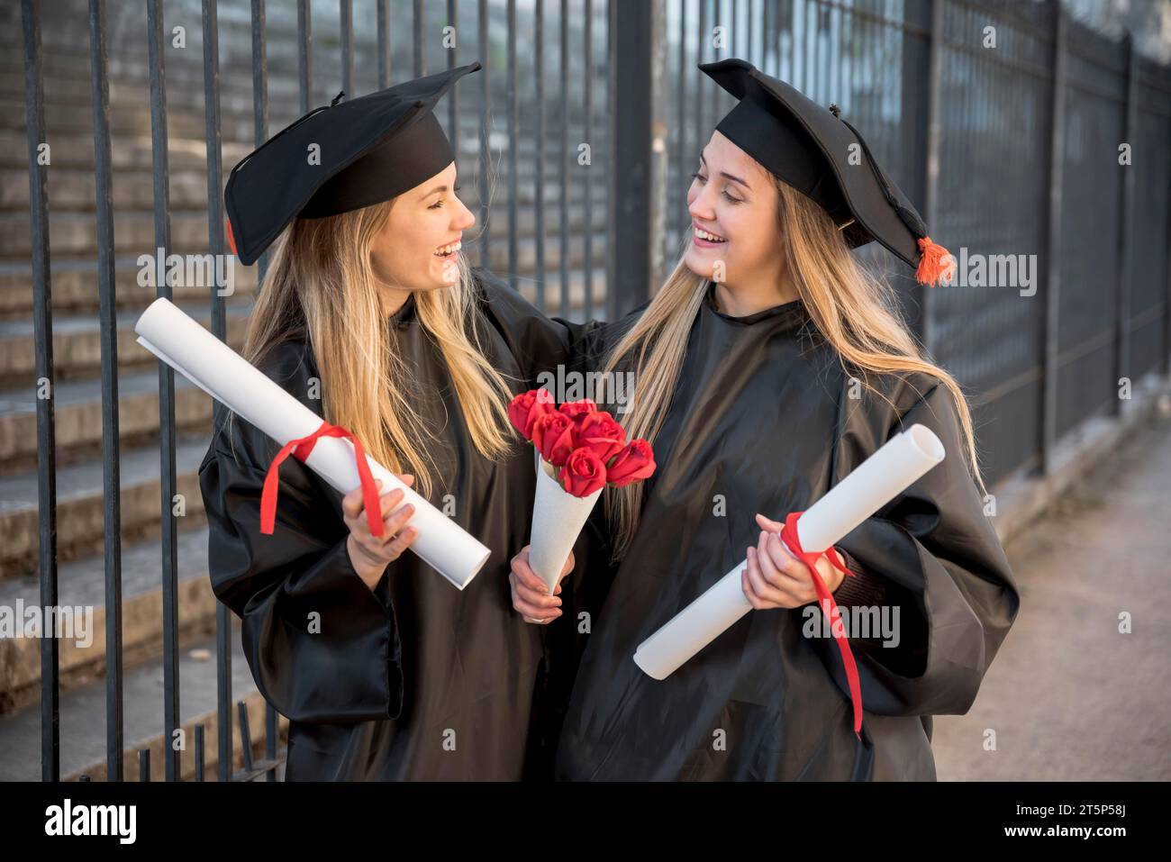Amis de vue moyenne avec bouquet roses graduation Banque D'Images