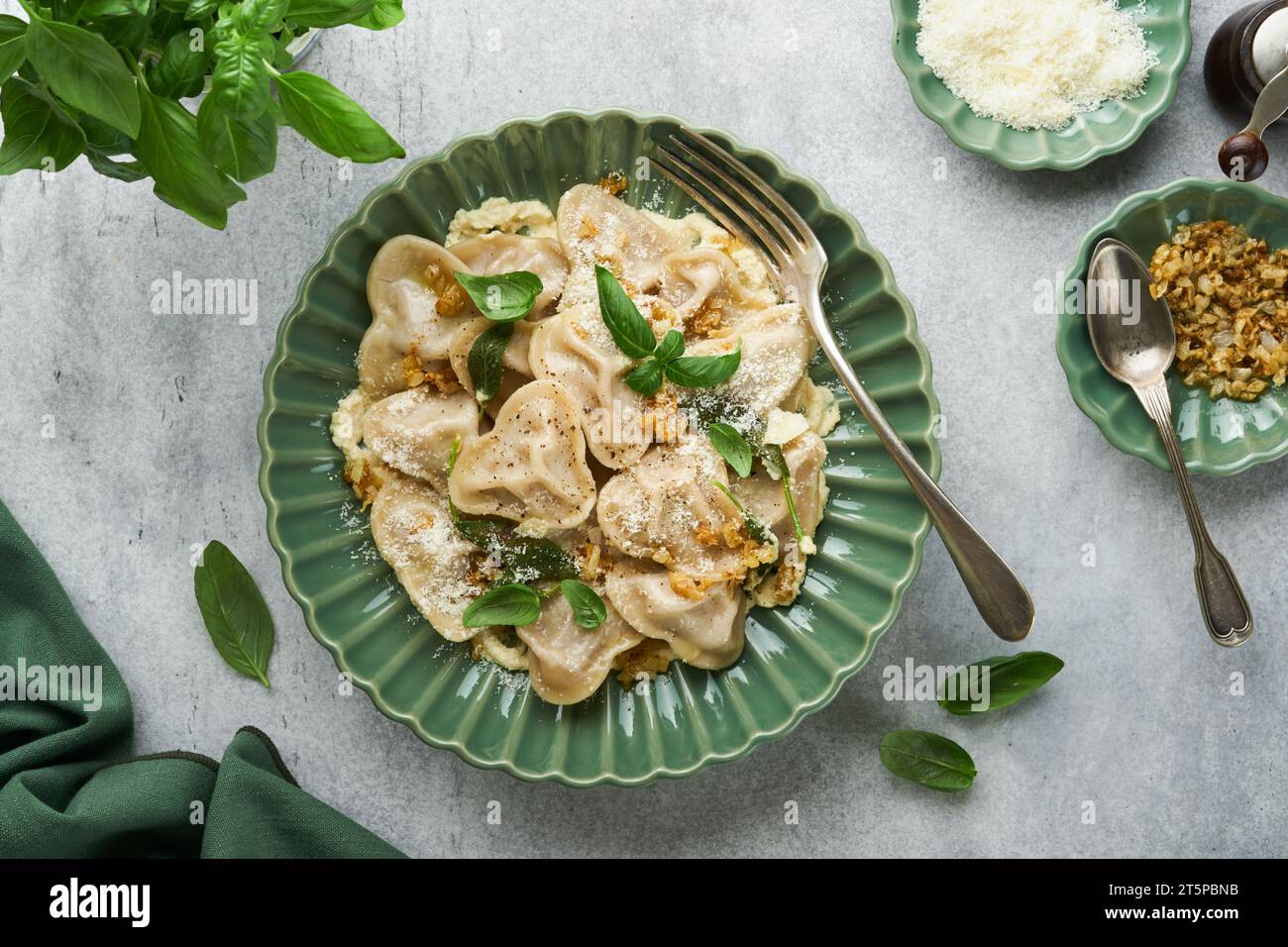 Pâtes maison italiennes ravioli en forme de coeur avec viande de boeuf, sauce au beurre au fromage, oignons caramélisés, basilic et safran sur fond gris ancien. Alimentation Banque D'Images