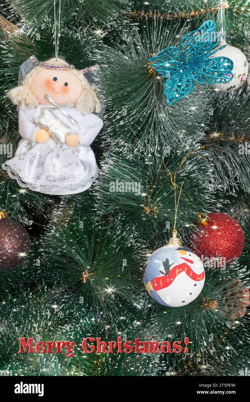 Magnifique fond avec bokeh et flocons de neige pour une carte de vœux de Noël avec des décorations sur les branches de l'arbre et un message de bienvenue. Banque D'Images