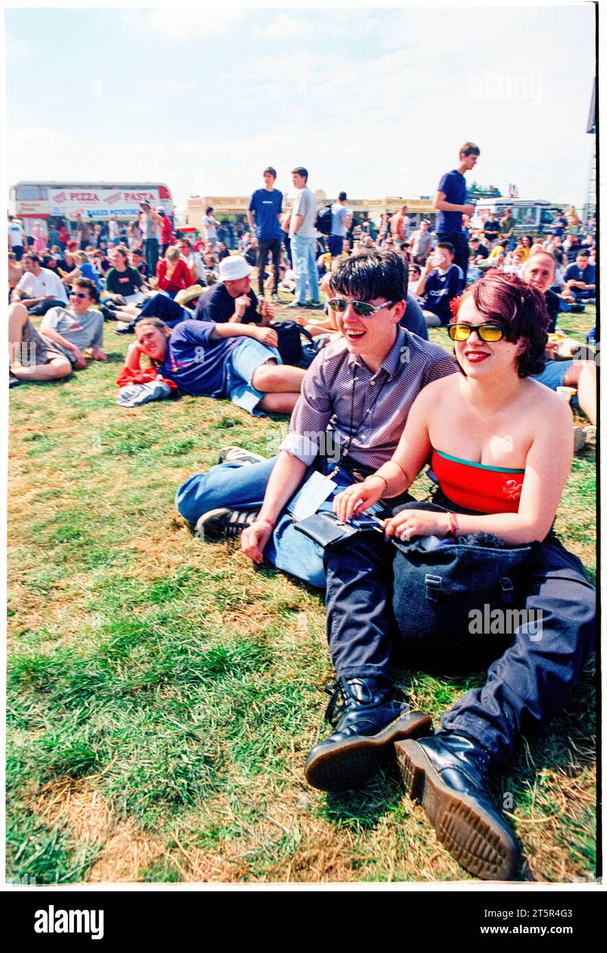 FANS DE BRITPOP et ROCK, READING FESTIVAL, 1998 : de jeunes amis partagent un moment de détente sur la scène principale. Une scène du site et de la foule dans la zone main Stage Arena au Reading Festival 1998 le 28-30 août 1998 à Reading, Angleterre Royaume-Uni. Photo : Rob Watkins Banque D'Images