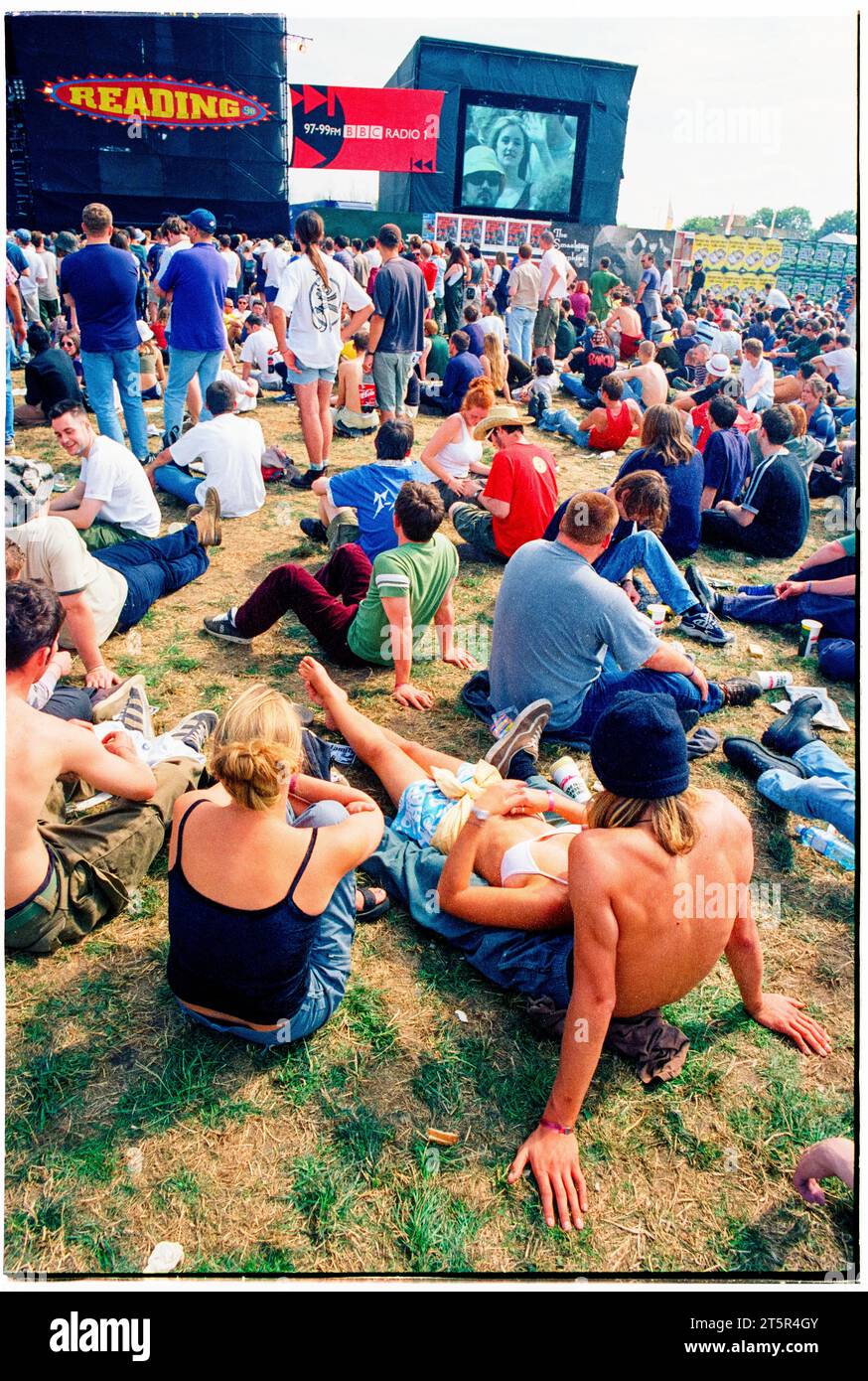 FANS DE BRITPOP et ROCK, READING FESTIVAL, 1998 : de jeunes amis partagent un moment de détente en prenant le soleil et en regardant la scène principale. Une scène du site et de la foule dans la zone main Stage Arena au Reading Festival 1998 le 28-30 août 1998 à Reading, Angleterre Royaume-Uni. Photo : Rob Watkins Banque D'Images