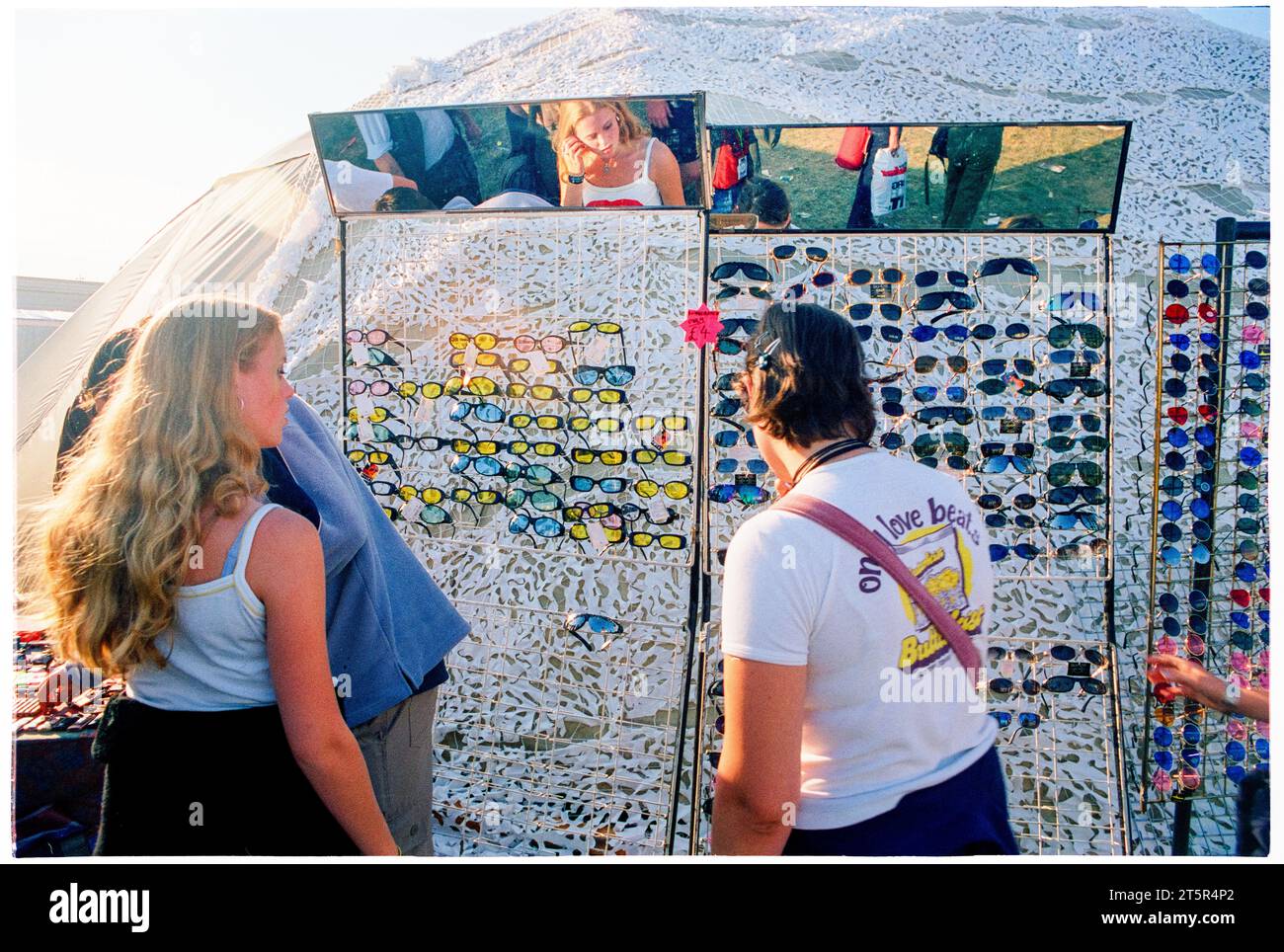 FANS DE BRITPOP et ROCK, READING FESTIVAL, 1998 : deux amis achètent des lunettes de soleil sur les stands du terrain principal. Une scène du site et de la foule dans la zone main Stage Arena au Reading Festival 1998 le 28-30 août 1998 à Reading, Angleterre Royaume-Uni. Photo : Rob Watkins Banque D'Images