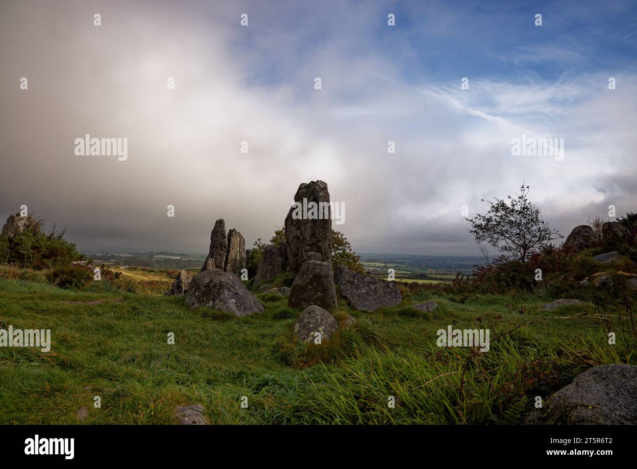 Des roches de granit déchiquetées se dressent sur un morceau de la lande de Cornouailles près du village de Roche tandis que les nuages de pluie se déplacent sur la campagne, Cornwall. Banque D'Images