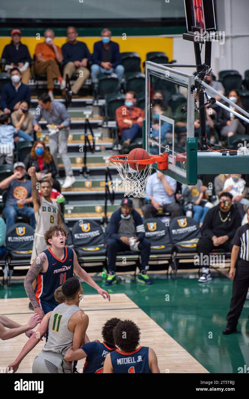 Joueur de basket-ball universitaire tirant sur un tir fait Banque D'Images