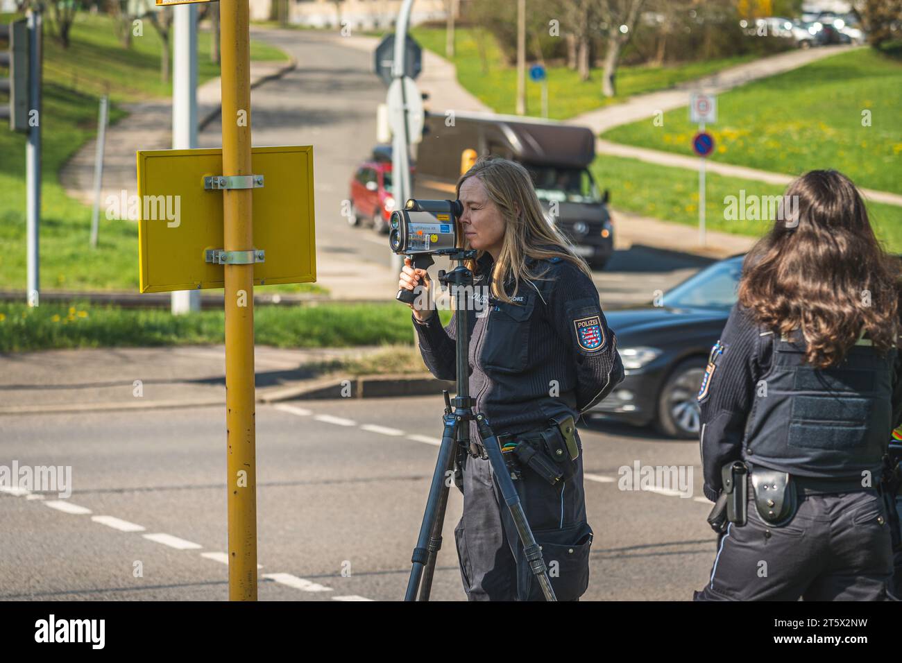 Eine Polizistin nutzt ein Lasermessgerät an einer Hauptstraße in Gera, UM die Geschwindigkeit der Fahrzeuge zu überprüfen. 21.04.2023 Banque D'Images
