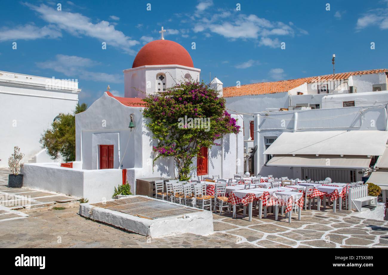 Mykonos Grèce terrasse de restaurant extérieur près de l'église avec dôme rouge. Banque D'Images
