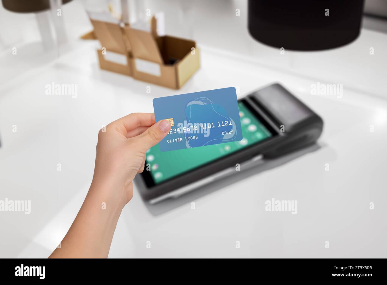 Paiement par carte sécurisé sur terminal POS élégant. Main tenant la carte de crédit pour la transaction. Processus de paiement sûr et pratique Banque D'Images