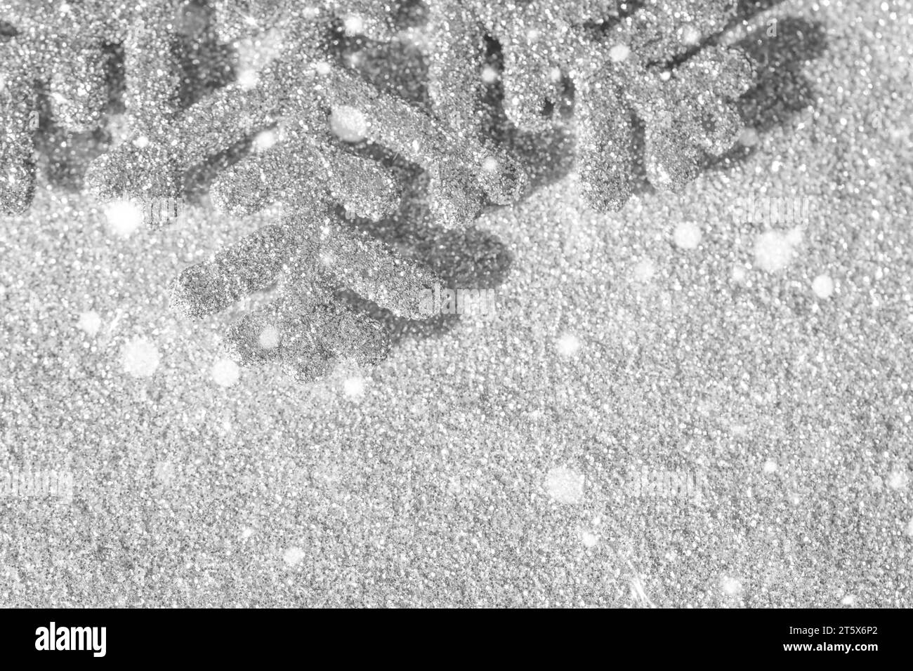 Fond de Noël - gros plan de flocon de neige de Noël argenté pailleté avec fond clair de bokeh flou Banque D'Images