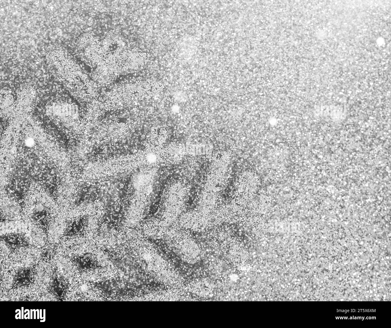 Ornement de flocon de neige argenté gros plan sur fond de Noël scintillant argenté clair abstrait. Banque D'Images