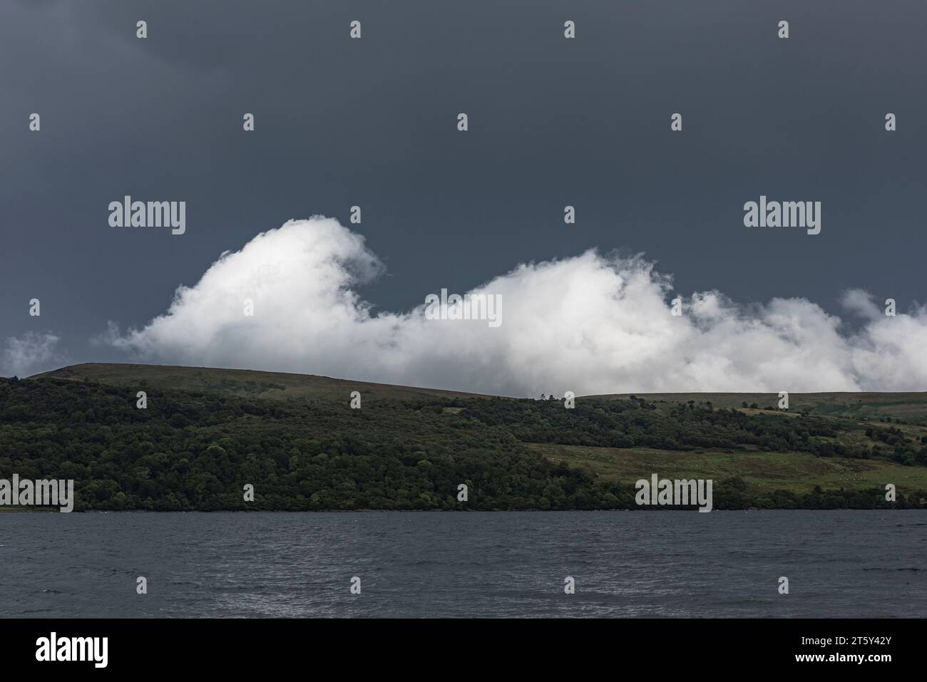 Un nuage blanc dramatique comme une vague brisante sur l'île de Bute, vu contre le ciel sombre d'une tempête qui approche (Écosse, Royaume-Uni) Banque D'Images