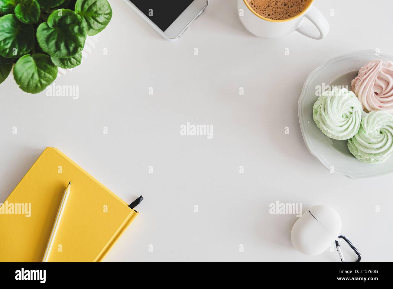 Maquette avec tablette, smartphone, ordinateur portable, tasse à café, nourriture et plante sur table blanche. Vue de dessus. Pose à plat Banque D'Images