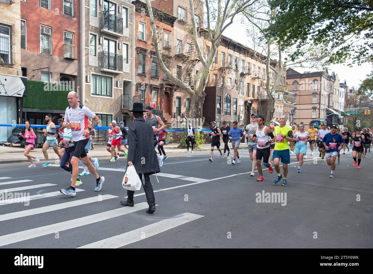 Un juif orthodoxe traverse la rue en évitant la foule de coureurs au marathon de New York en 2023. A Williamsburg, Brooklyn Banque D'Images