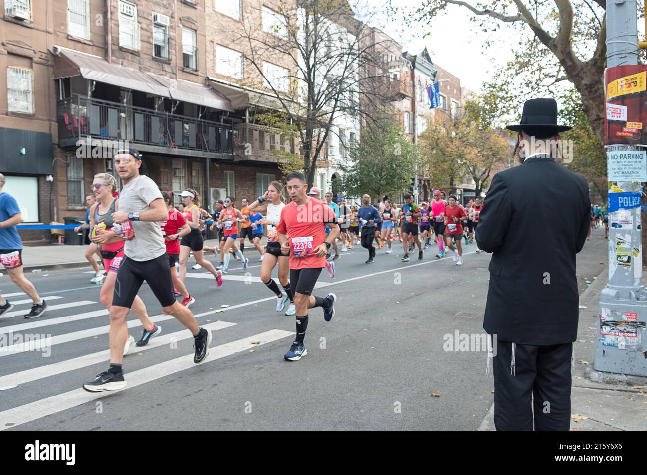 Un juif orthodoxe contemple comment traverser la rue et éviter la foule de coureurs au marathon de New York 2023. A Williamsburg, Brooklyn Banque D'Images