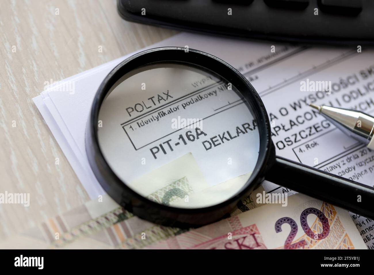 Déclaration du montant des cotisations d'assurance maladie payées et déduites de la carte d'impôt dans les mois individuels de l'année d'imposition, formulaire PIT-16a sur la table comptable avec stylo et factures d'argent zloty poli Banque D'Images