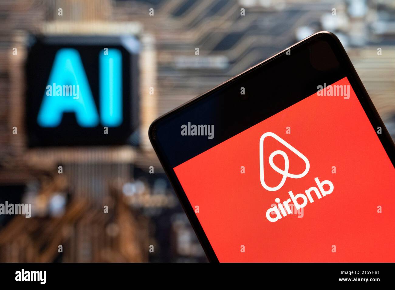 Dans cette illustration photo, le logo du marché en ligne américain et du service hôtelier Airbnb (NASDAQ : ABNB) est affiché sur un smartphone avec une puce d'intelligence artificielle (IA) et un symbole en arrière-plan. Banque D'Images