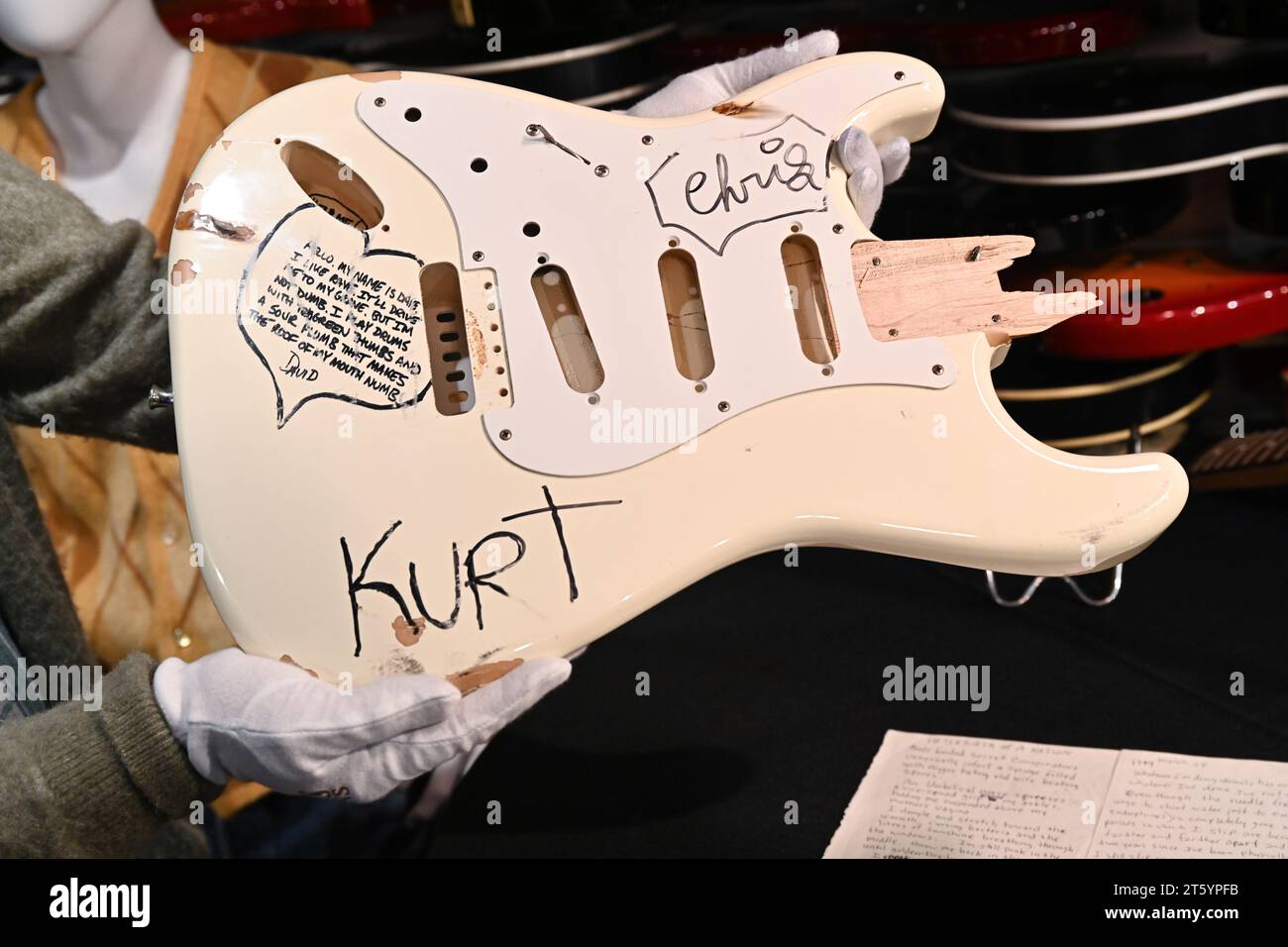 Scène-Played de Kurt Cobain et Smashed Cream Fender Stratocaster exposés lors de l'avant-première médiatique pour l'icône du rock'n'roll joué, usé, déchiré de Julien Banque D'Images