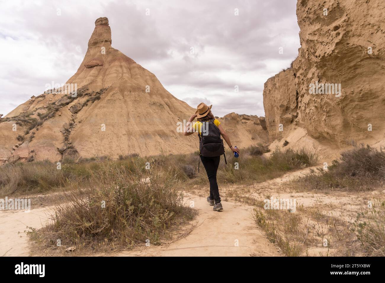 Femme avec sac à dos marchant le long d'un parc national aride Banque D'Images