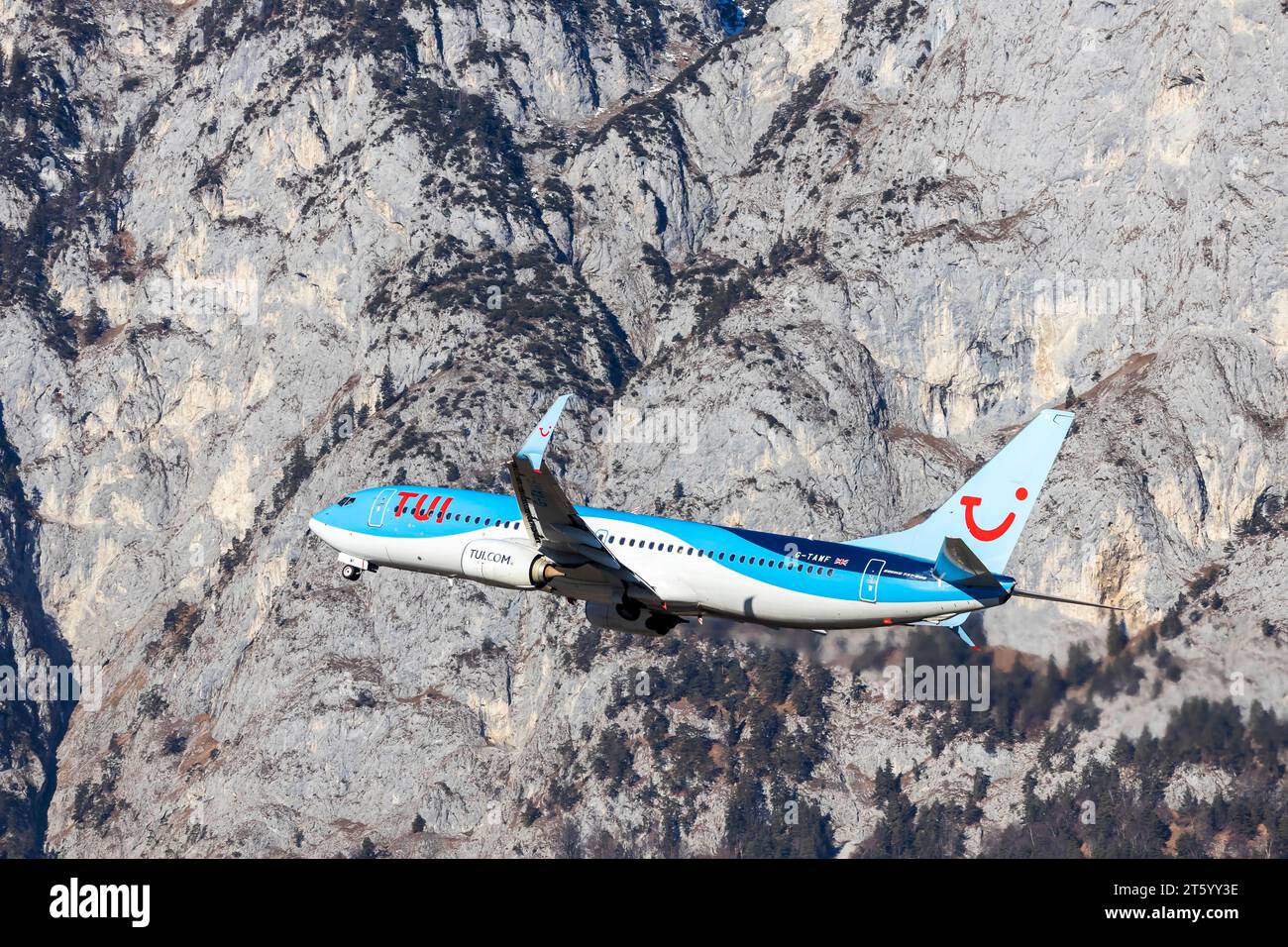 Avion de la compagnie aérienne TUI décollant à l'aéroport d'Innsbruck Kranebitten, Boeing 737-800. Montagnes enneigées des Alpes, Innsbruck, Tyrol, Autriche Banque D'Images