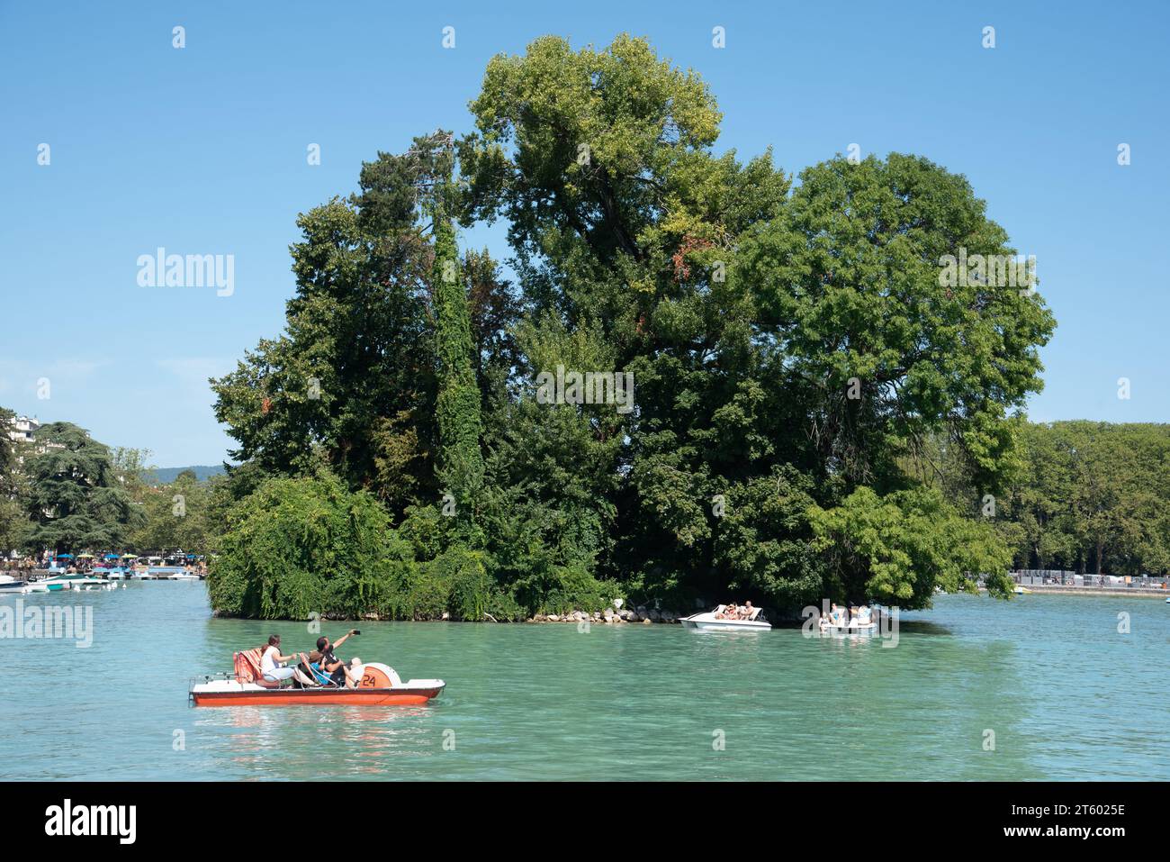 Touristes sur pédalo, pédalo ou Paddle Boat & Île des Cygnes, ou île des cygnes, Lac d'Annecy ou Lac d'Annecy haute-Savoie France Banque D'Images