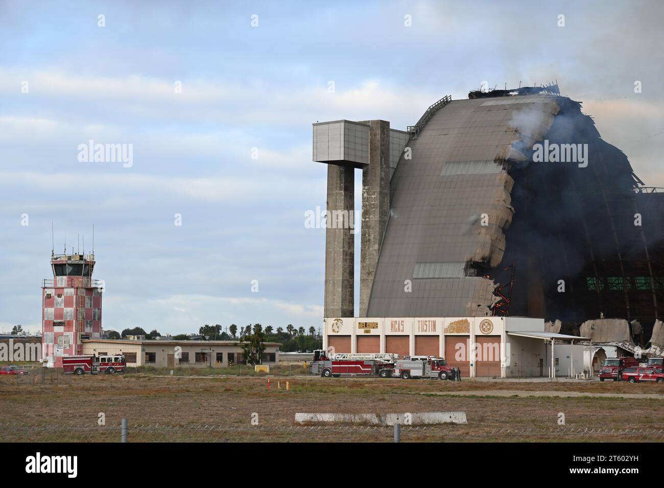 TUSTIN, CALIFORNIE - 7 NOVEMBRE 2023 : le hangar MCAS Tustin Blimp en feu, avec la tour de contrôle et les équipes de pompiers. Banque D'Images