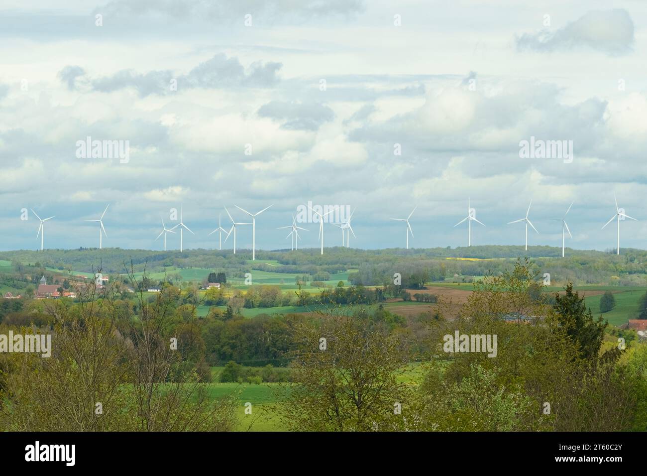 Éoliennes sur le fond du champ, montagnes et nuages. Banque D'Images