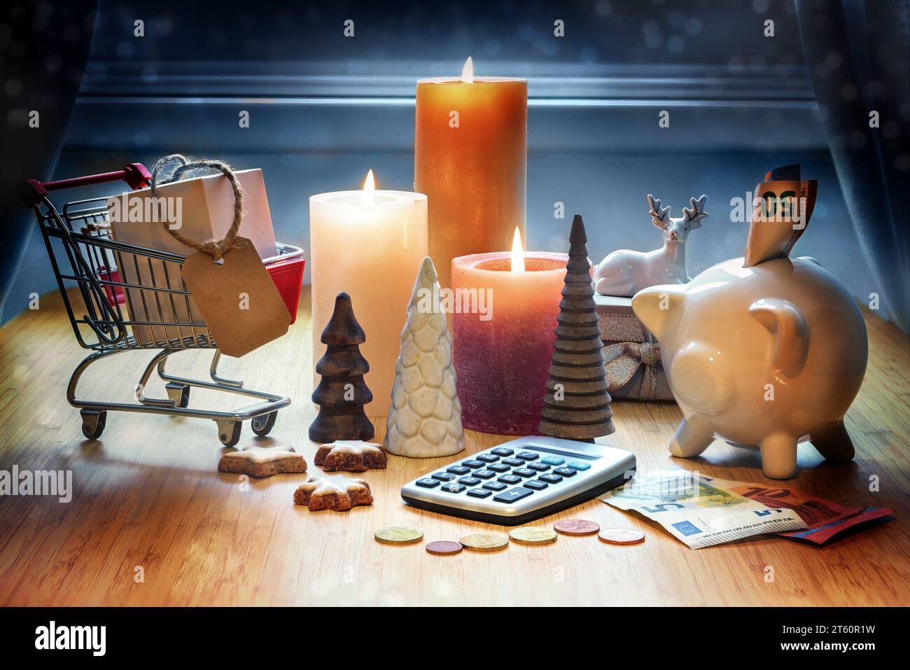 Shopping de vacances. Calculatrice, décoration de Noël, calculatrice, tirelire, panier et bougies sur une table sur fond bleu. Espace de copie Banque D'Images