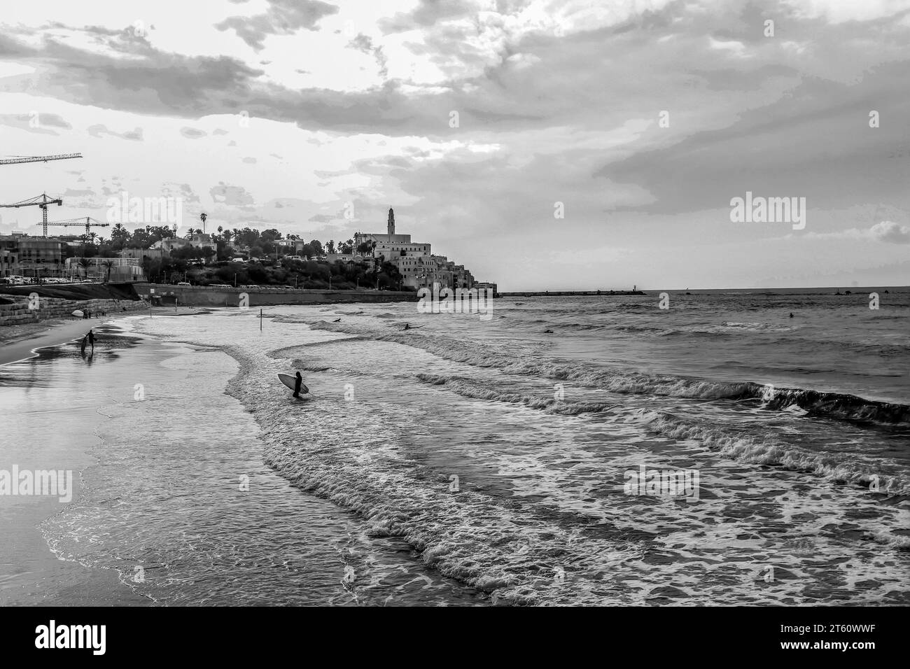 Surfeurs à tel Aviv en Méditerranée . Contexte - région de Jaffa. Photo noir et blanc. Personnes à distance - personnes méconnaissables. Mono stylisé Banque D'Images