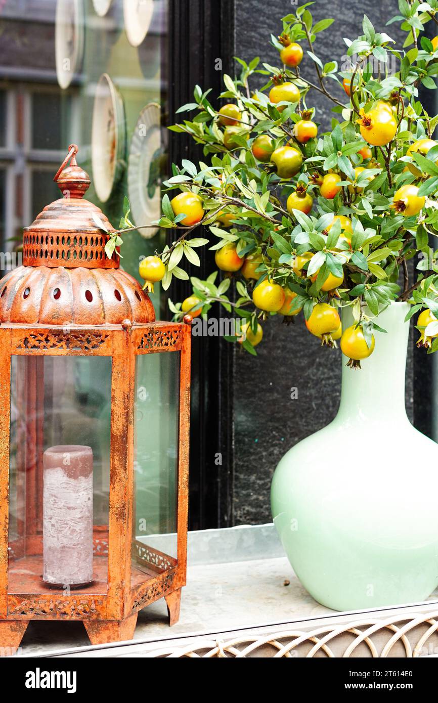 Gros plan de lampe bougie antique et vase avec baies sauvages décoratives Banque D'Images