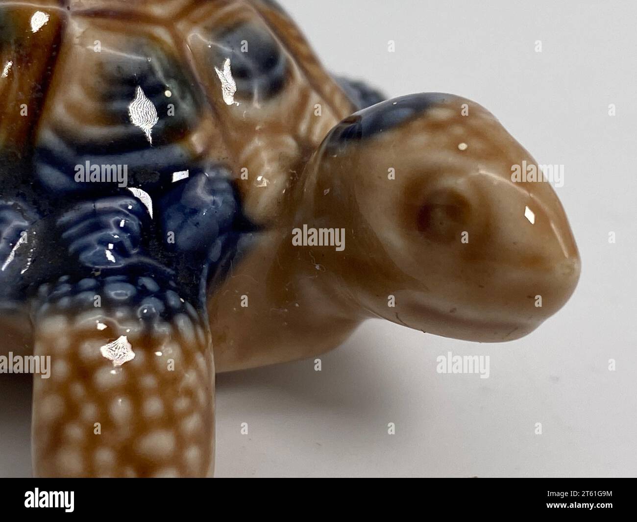 Une petite figurine en céramique en forme de tortue, avec une coquille peinte en vert et des traits faciaux détaillés Banque D'Images