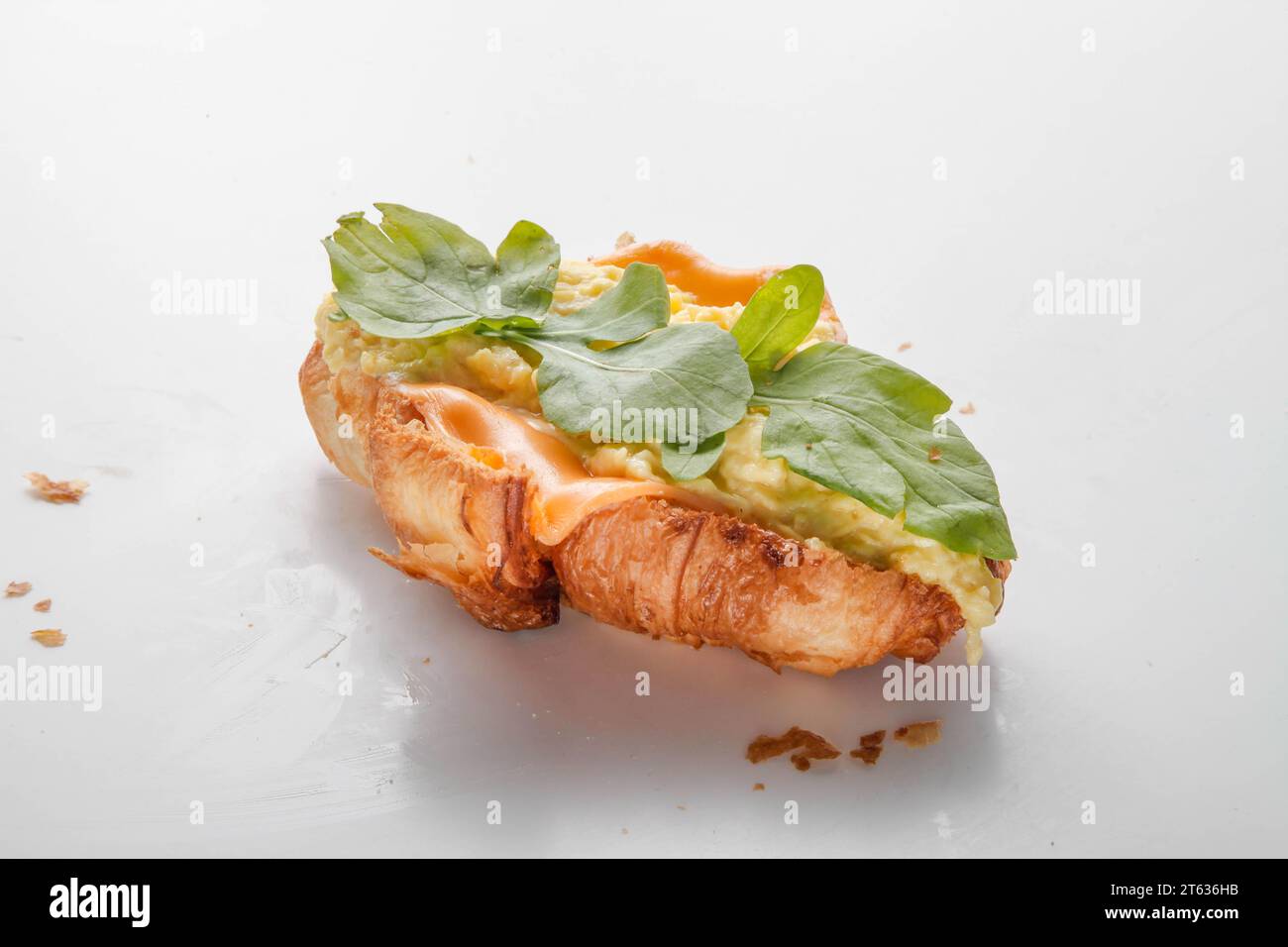 Petit déjeuner sandwich croissant aux œufs brouillés. Banque D'Images
