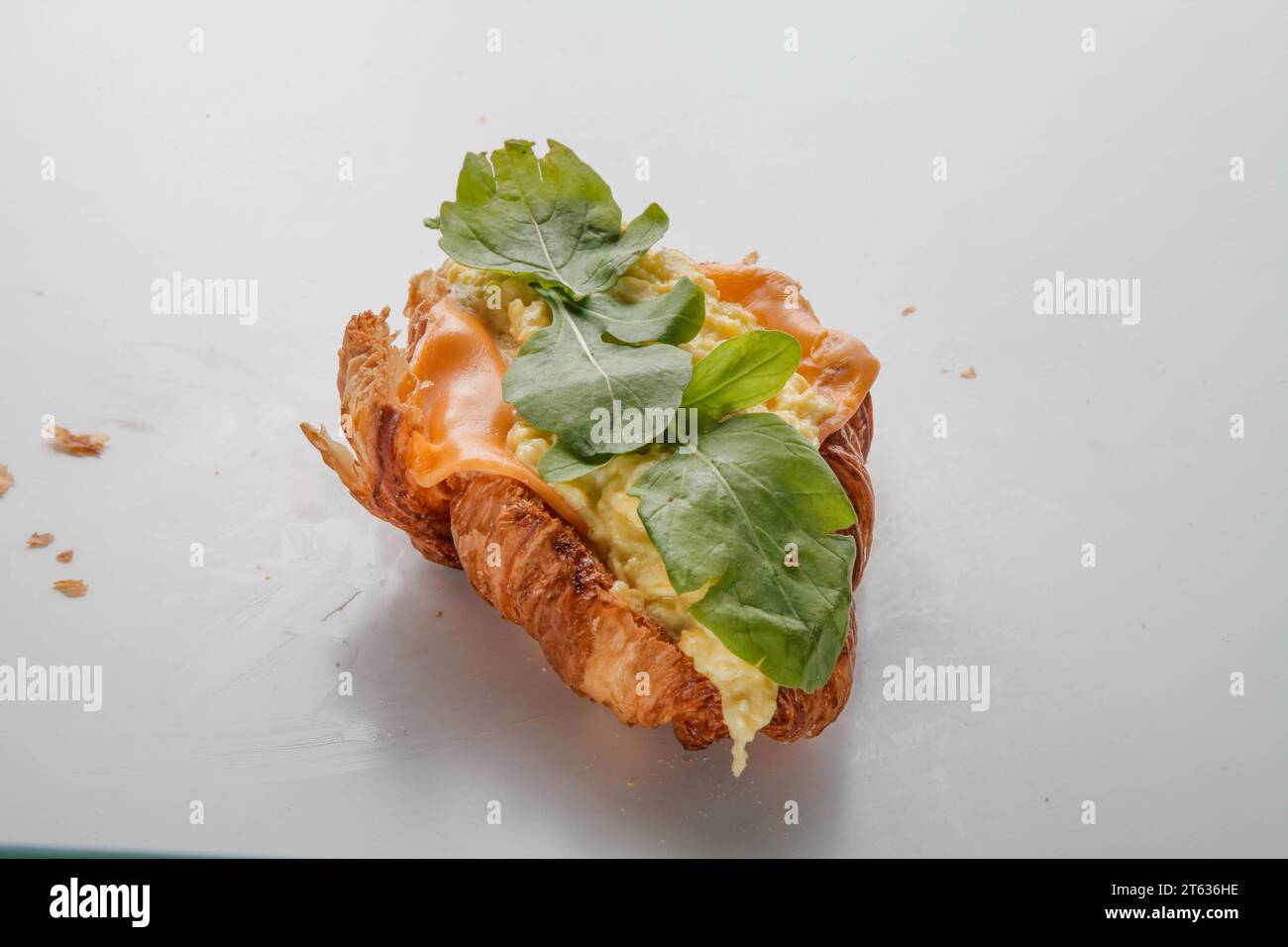 Petit déjeuner sandwich croissant aux œufs brouillés. Banque D'Images