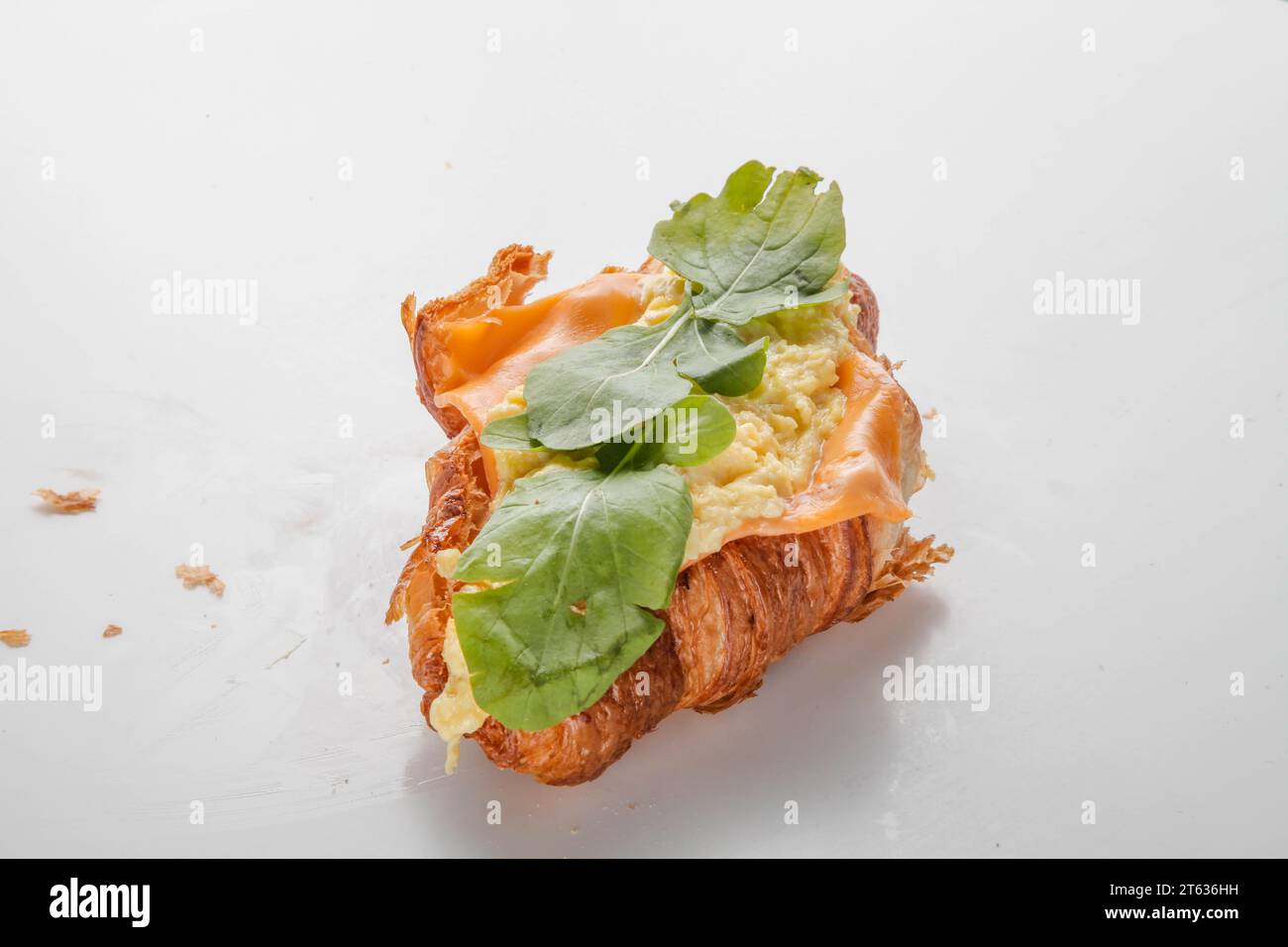 Petit déjeuner sandwich croissant aux œufs brouillés. Banque D'Images