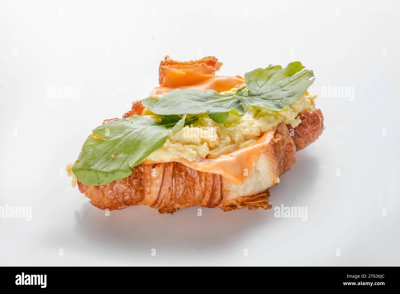 Petit déjeuner sandwich croissant aux œufs brouillés. Banque D'Images