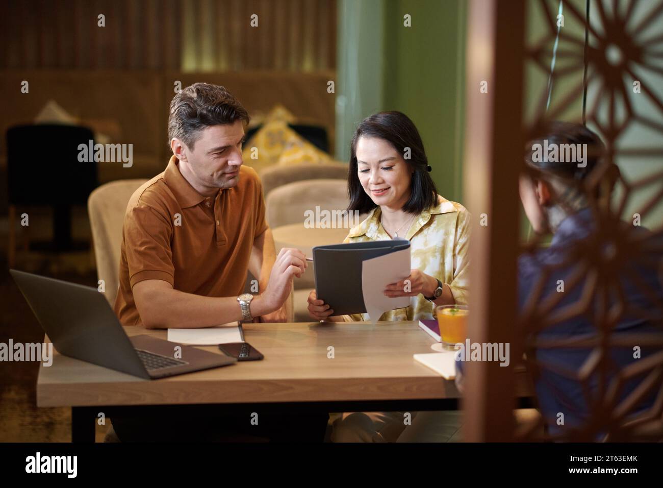 Les partenaires commerciaux relisent ensemble le contrat avant de le signer Banque D'Images