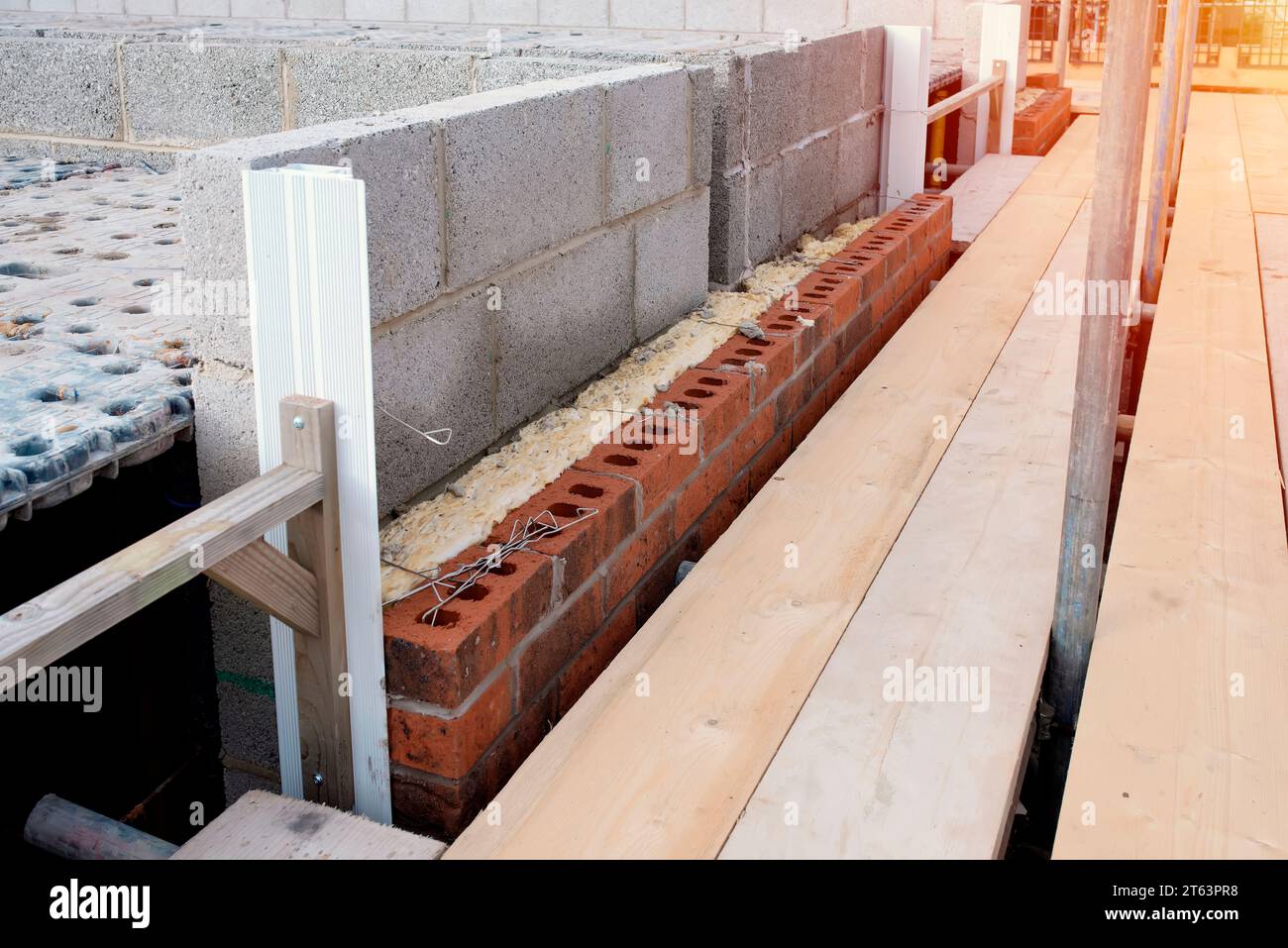 Isoler les murs des maisons neuves en plaçant de la laine de roche à l'intérieur des cavités murales dans le cadre des mesures d'économie d'énergie. Maison isolée avec woo minéral Banque D'Images