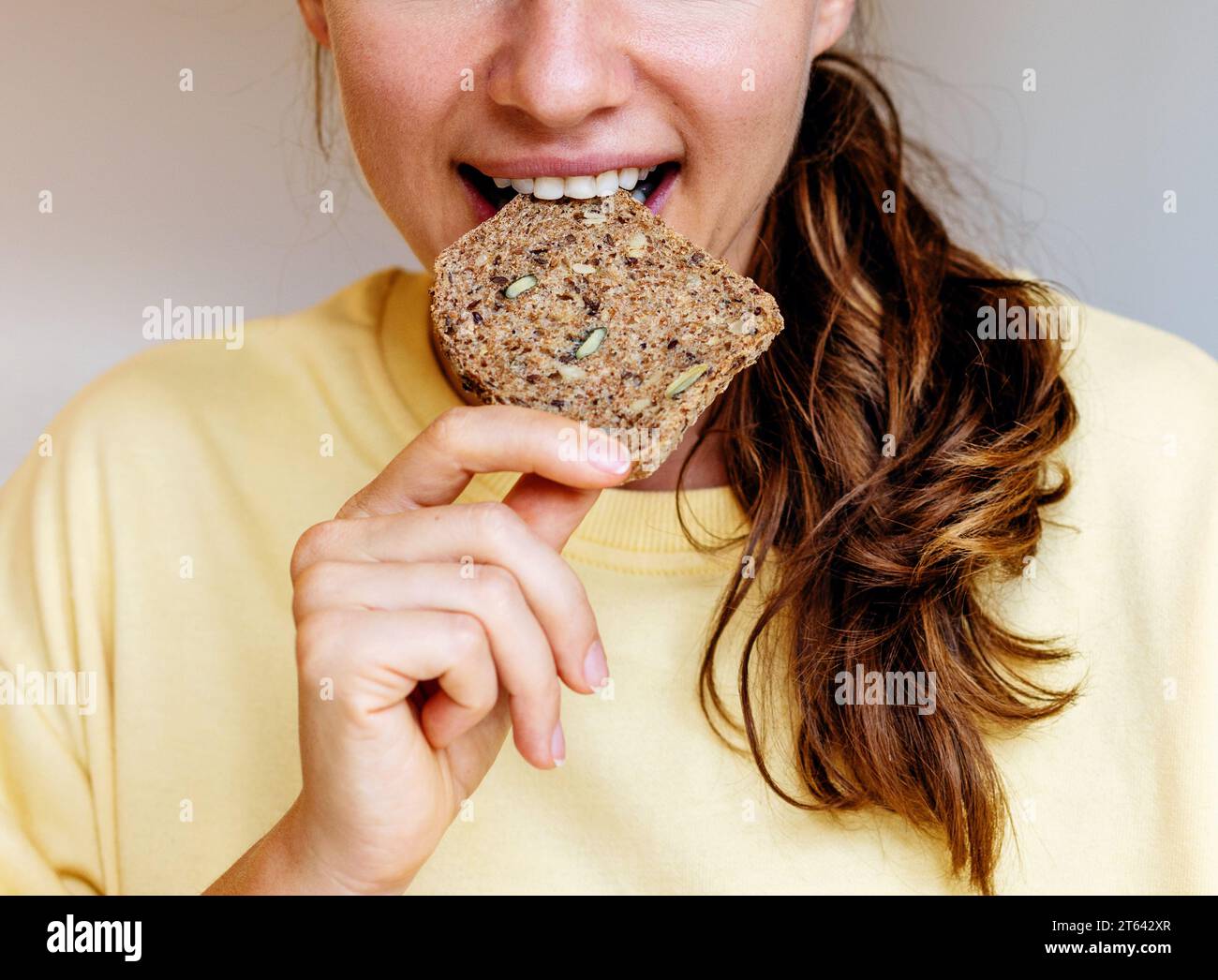 Femme mangeant du pain de grain gros plan. Alimentation saine et fond d'alimentation. Banque D'Images