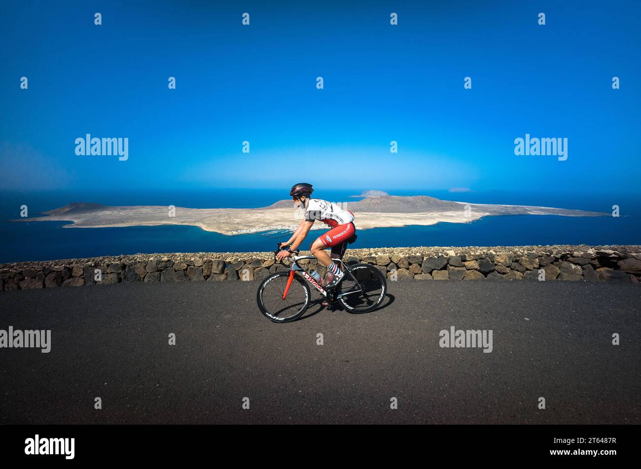 Espagne, Canaries, la Graciosa : un cycliste passe devant l'île de la Graciosa sur la route Mirador del Rio à Lanzarote Banque D'Images