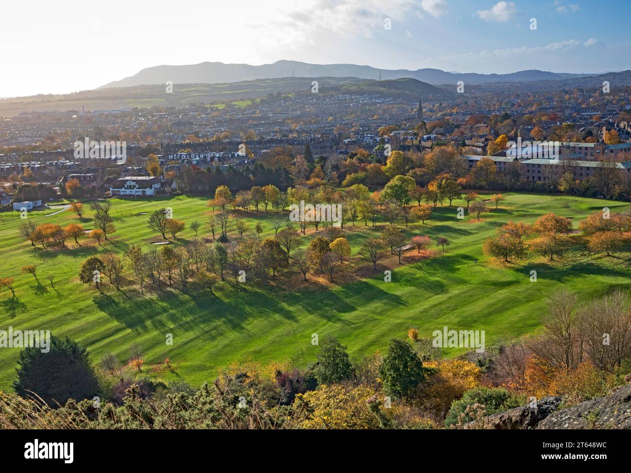 Prestonfield Édimbourg, Écosse, Royaume-Uni. 8 novembre 2023. Enfreindre les règles de la photographie consistant à éviter de prendre des photos dans la lumière (contre jour) a permis dans ce cas au soleil éclatant de mettre en évidence les couleurs automnales brillantes des arbres à feuilles caduques, en particulier ceux dans les terrains du Prestonfield Golf course au premier plan ainsi que au-delà des collines brumeuses de Pentland en arrière-plan, photographiés depuis Holyrood Park. Banque D'Images