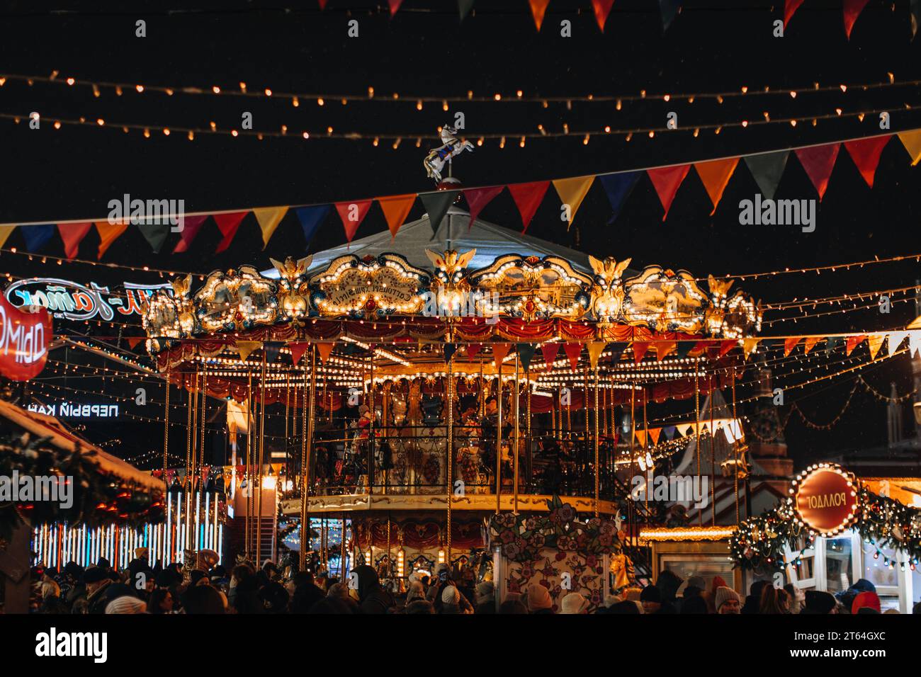 Vacances magiques à Moscou. Amusez-vous dans le manège magique pour enfants dans l'atmosphère du nouvel an avec des gens qui se promènent et des guirlandes festives. Banque D'Images