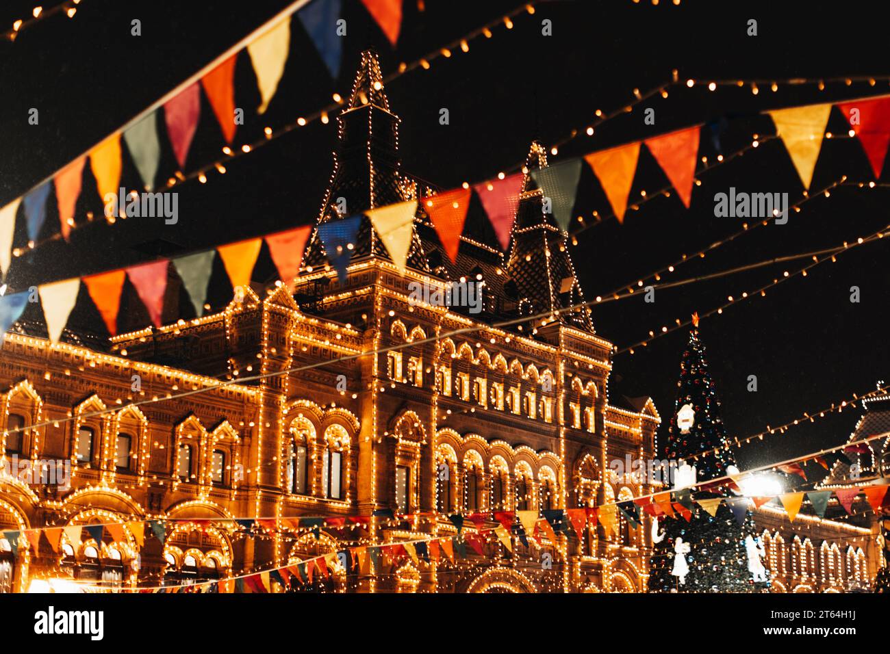 Nouvel an et ambiance de Noël dans le centre de Moscou. Bâtiment doré brûlant avec illumination magique du soir et décoré de guirlandes festives Banque D'Images