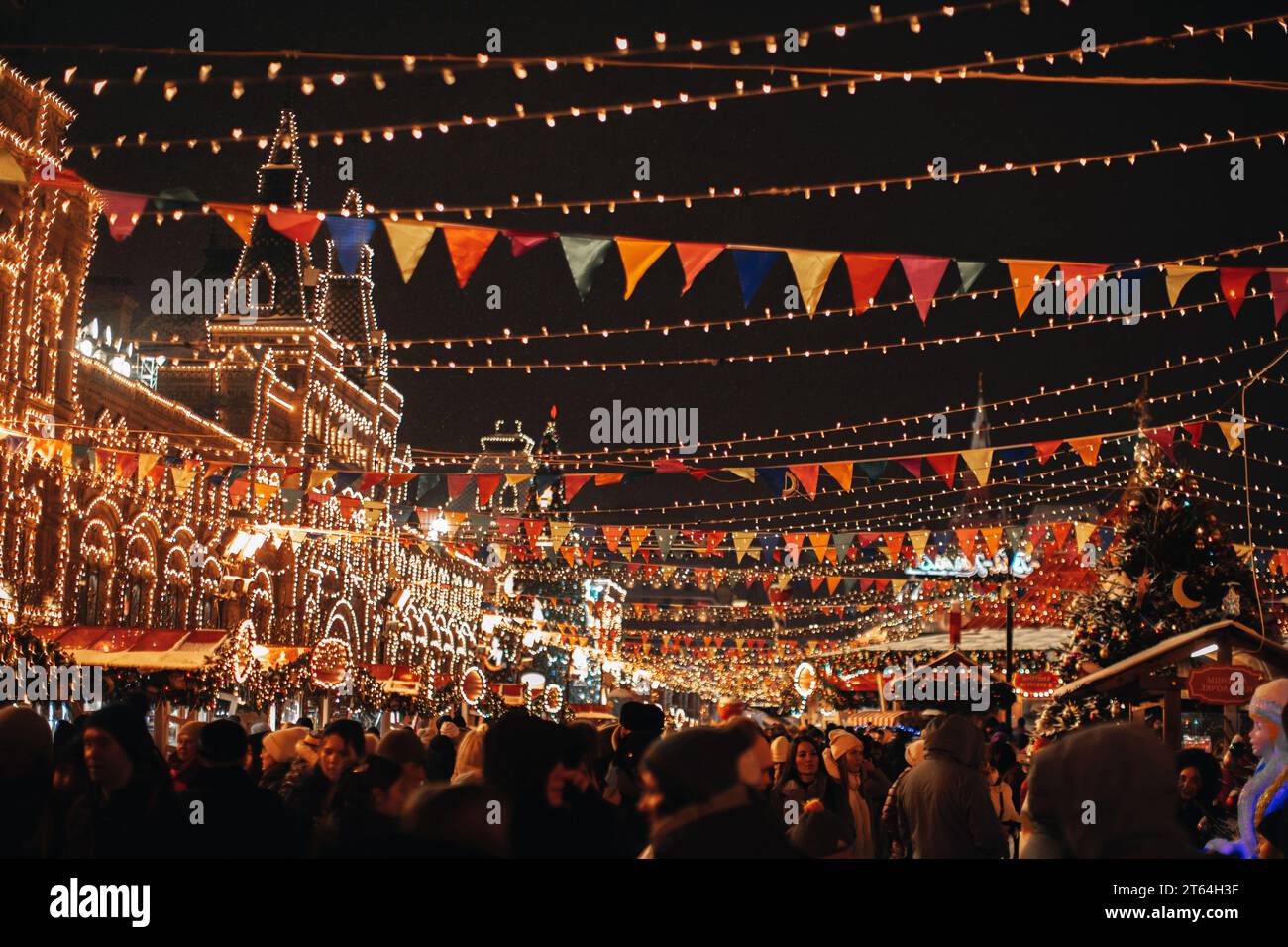Une foule de personnes marchant dans la soirée à la célèbre foire de Noël dans le centre de Moscou décorée avec des guirlandes dorées festives.Atmosphère magique Banque D'Images