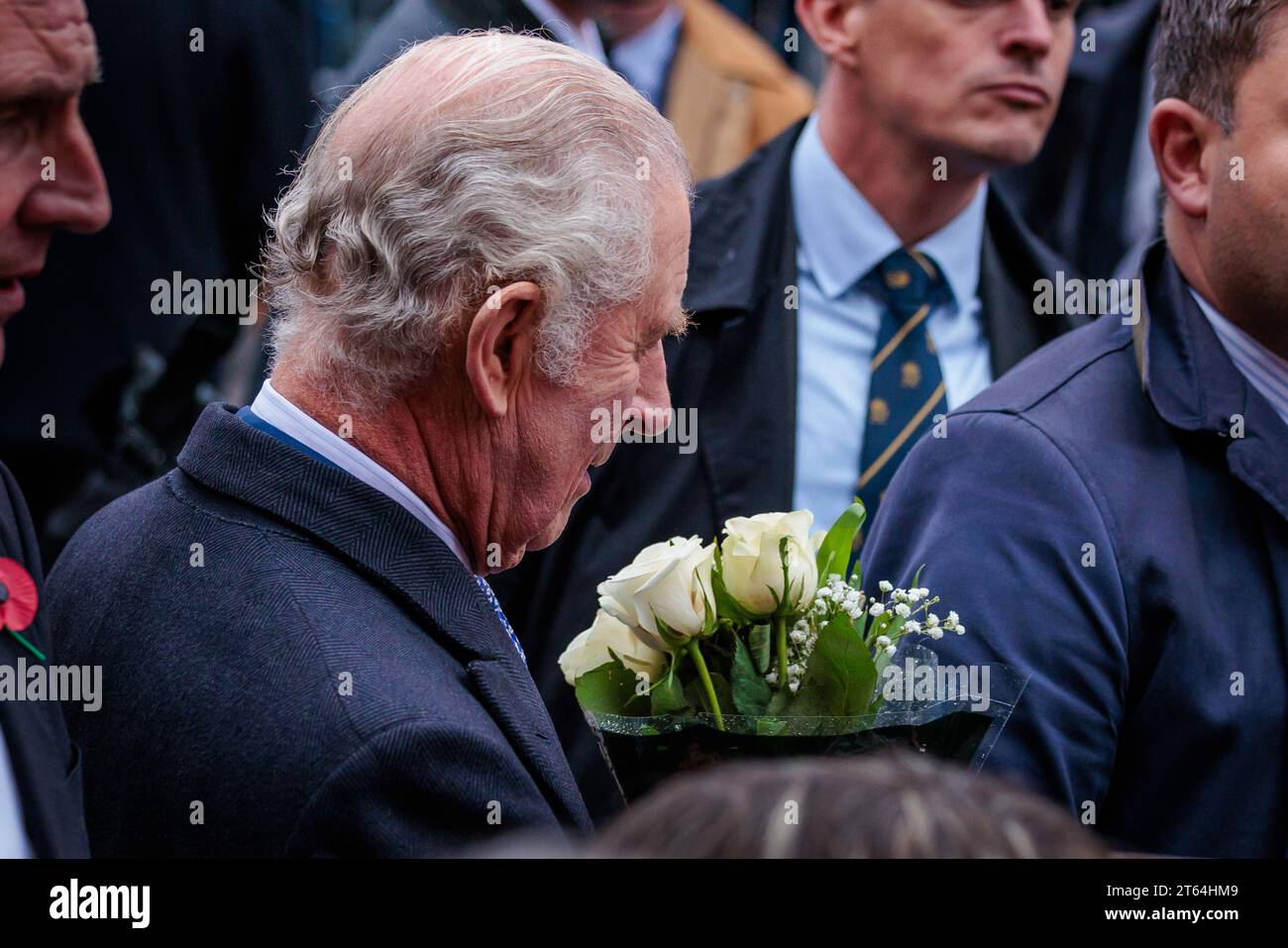 New Malden, Londres, Royaume-Uni. 8 novembre 2023. Sa Majesté le Roi Charles III se rend à New Malden pour passer du temps avec la communauté coréenne de la région, avant la visite d’État du Président de la République de Corée et de la première Dame plus tard ce mois-ci. Le Roi admirant un bouquet de fleurs qui lui est présenté lors d'une promenade pour saluer la foule de gens qui avaient attendu sous la pluie pendant des heures pour le rencontrer. Photo par Amanda Rose/Alamy Live News Banque D'Images