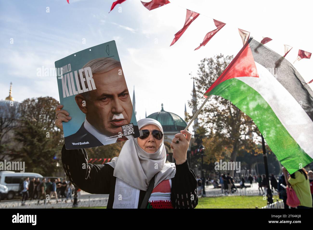 Istanbul, Turquie. 08 novembre 2023. Une manifestante tient une pancarte avec la photo du Premier ministre israélien Benjamin Netanyahu et les mots "tueur d'enfants" dessus, ainsi que le drapeau palestinien lors d'un sit-in. L'Initiative de solidarité avec les femmes palestiniennes se poursuit le 8e jour de la manifestation sit-in de 15 jours sur la place Sultanahmet. Crédit : SOPA Images Limited/Alamy Live News Banque D'Images