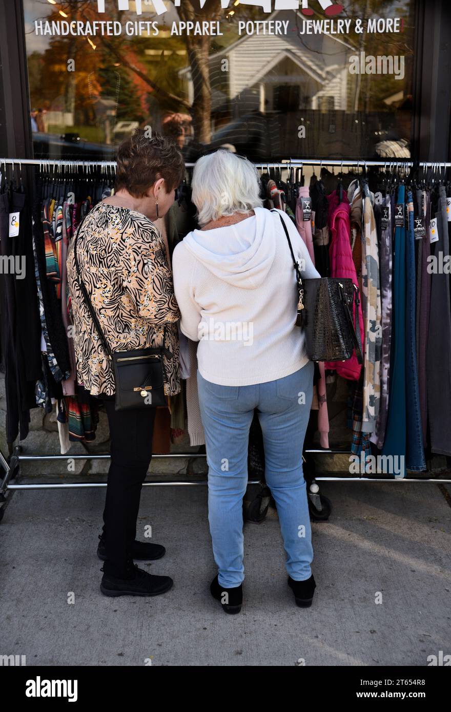 Les acheteuses regardent un rack de vêtements à vendre à l'extérieur d'un magasin de vêtements pour femmes à Blowing Rock, en Caroline du Nord Banque D'Images