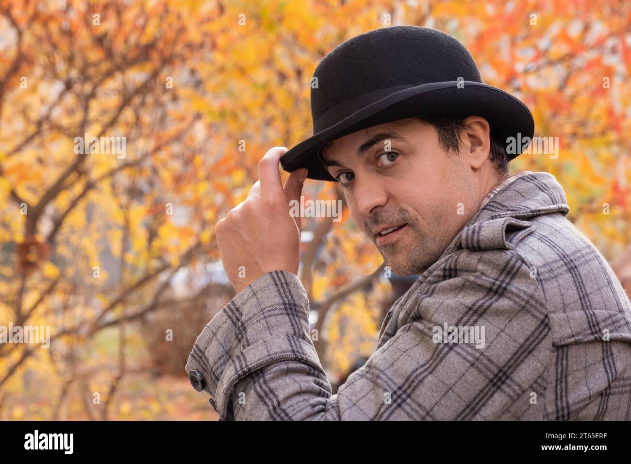 Portrait d'un homme dans un chapeau et manteau à carreaux à l'extérieur par une journée ensoleillée d'automne Banque D'Images