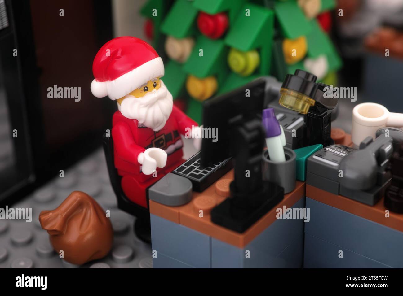 Tambov, Fédération de Russie - 08 novembre 2023 Une minifigurine Lego du Père Noël travaillant sur un ordinateur dans son bureau. Gros plan. Banque D'Images