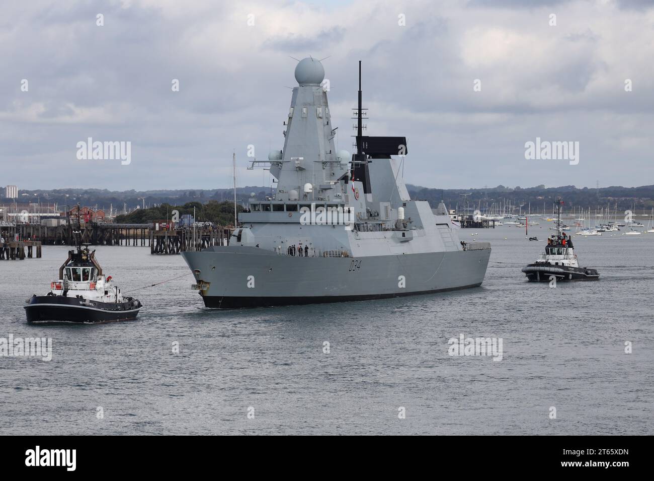 Des remorqueurs GÉNÉREUX et INDULGENTS escortent le navire de guerre HMS DIAMOND DE la Royal Navy vers l'embouchure du port alors que le destroyer quitte la base navale Banque D'Images