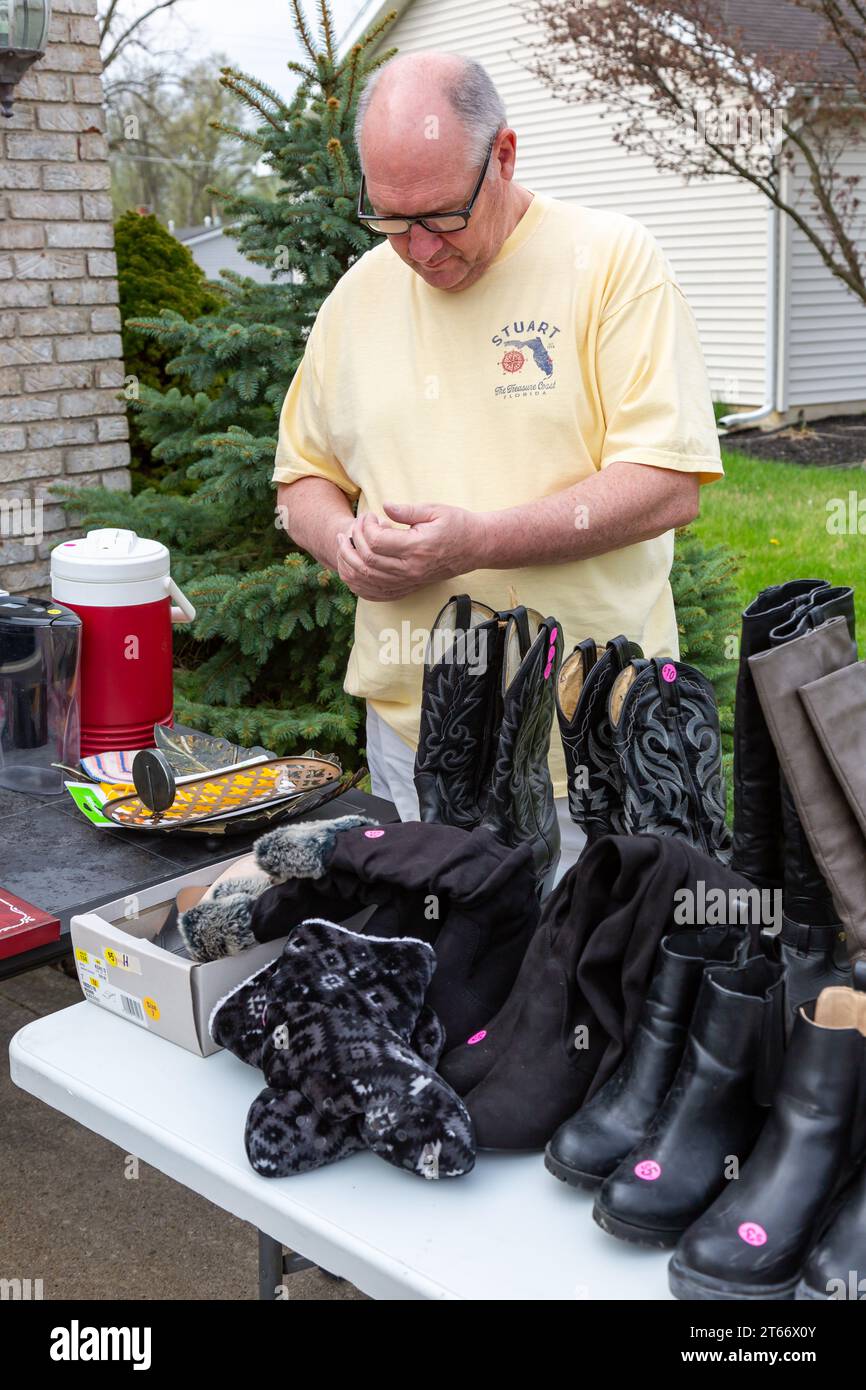 Un homme vérifie un article dans une vente de garage à fort Wayne, Indiana, USA. Banque D'Images