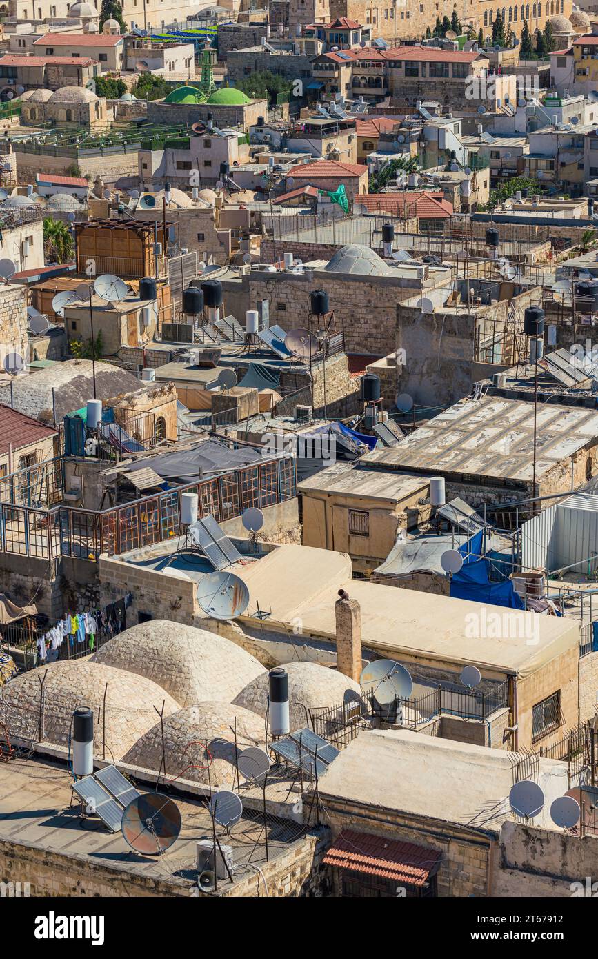 Vue chaotique sur le toit d'une ville du Moyen-Orient avec antennes paraboliques et réservoirs d'eau Banque D'Images